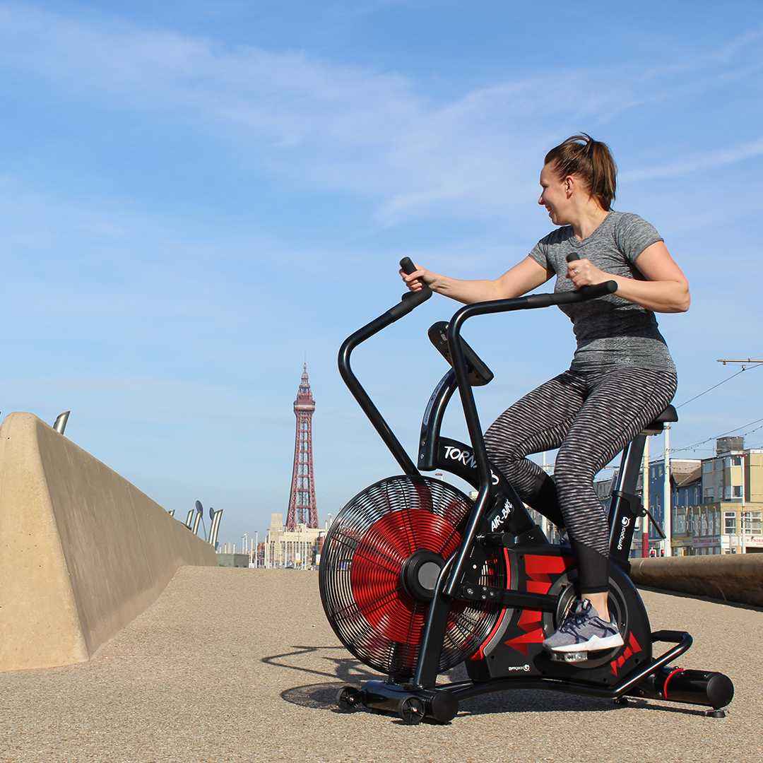 Woman exercising on the Gym Gear Tornado Airbike exercise bike with Blackpool Tower in the background
