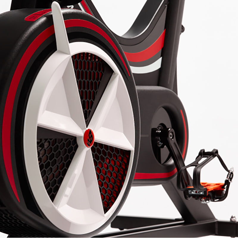 Close-up of a Wattbike pro trainer wheel and foot pedal with red and black design on a white background