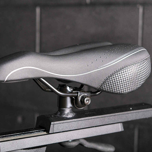 Close-up of the Gym Gear M Sport Elite Indoor Cycle exercise bike seat with a textured surface on a blurred background