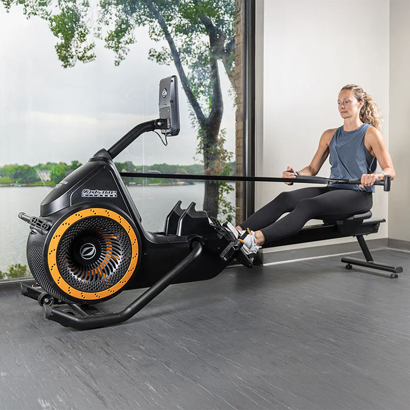 Woman using the OCTANE RŌ Rower rowing machine in a her home.