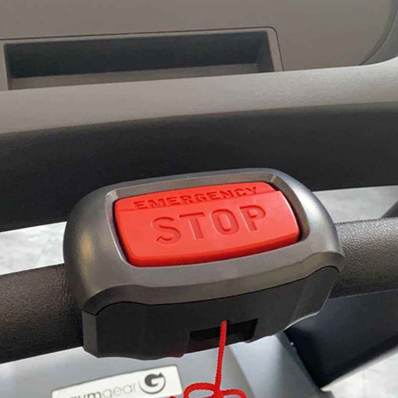 Close-up of the emergency stop button on the treadmill dashboard with red 'EMERGENCY STOP' label.