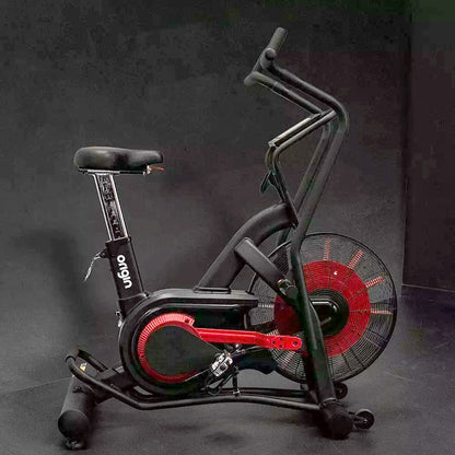 Origin Storm Air Bike exercise bike. Full view of the bike from the side on a dark background